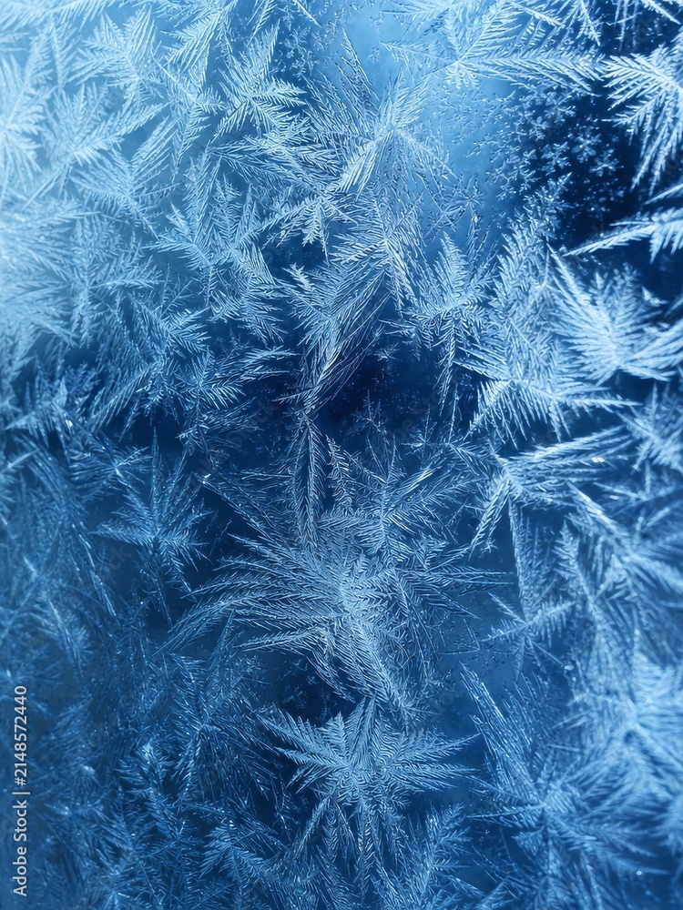 Obraz premium Close-up frost patterns on glass window with intricate ice crystals and winter Snowflake texture