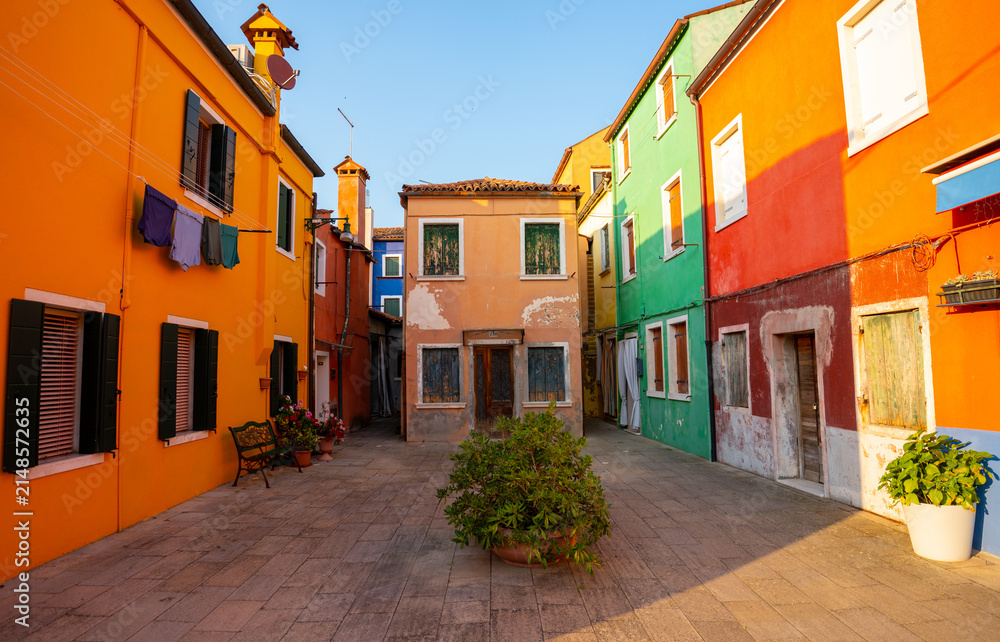 Fototapeta premium Colorful houses vibrant street view with paved courtyard in Burano island Venice Italy daylight architecture landmark scene