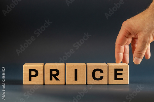 Price symbol. Businessman hand arranging wooden blocks spelling the word Price. Corporate finance strategy, inflation costs and market valuation concept on navy blue background. Copy space