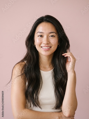 Portrait of a beautiful young asian woman with long black hair smiling at the camera