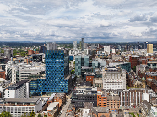 Aerial view of the modern cityscape of Manchester featuring the blue glass tower of No.1 Spinningfields surrounded by urban architecture in Manchester, England, United Kingdom.