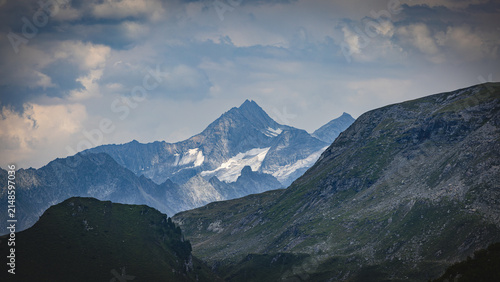 Alpine mountain landscape featuring glaciers and cloudy sky