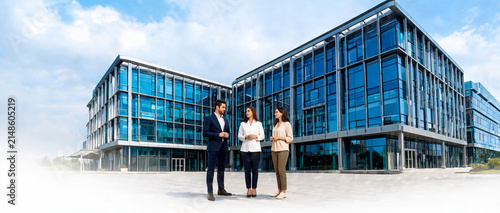 Corporate Team Posing in Front of Glass Office Building Outdoors