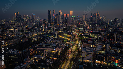 Aerial view of the Melbourne skyline at dusk with illuminated skyscrapers, busy city roads, and urban architecture in Parkville, Victoria, Australia.