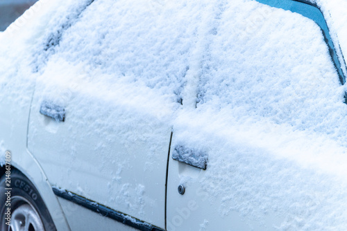 Obraz na plátne Close up of a white car covered in fresh cold snow The Concept of freezing winte