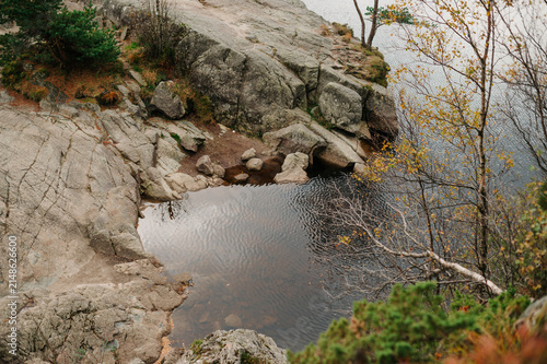 Rocky Norwegian coastline with calm water and autumn foliage