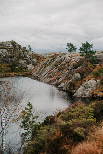 Rugged Norwegian coastline with a calm lake and sparse evergreen trees