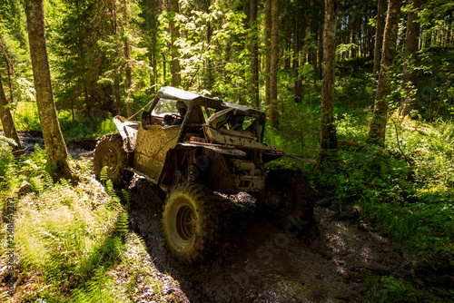 View of an off-road vehicle driving through a muddy forest path near Lake Ladoga in Sortavala, Respublika Kareliya, Russia.