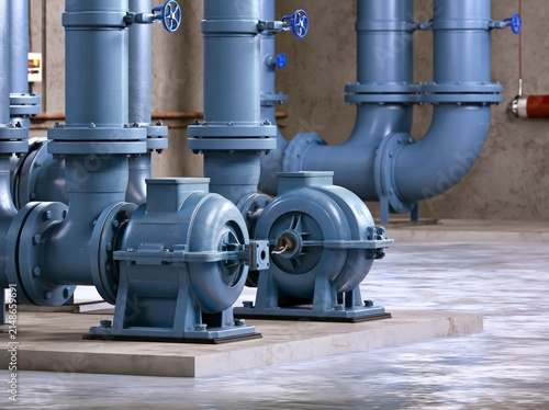 Twin pumps in a dry pit sewage lift station with discharge and suction pipes on a concrete floor