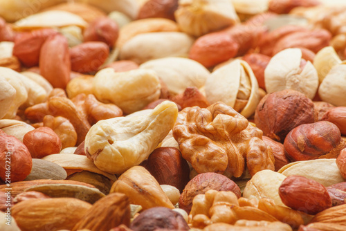 Картината върху платно Variety of nuts and seeds closeup with selective focus - peeled walnut, hazelnut