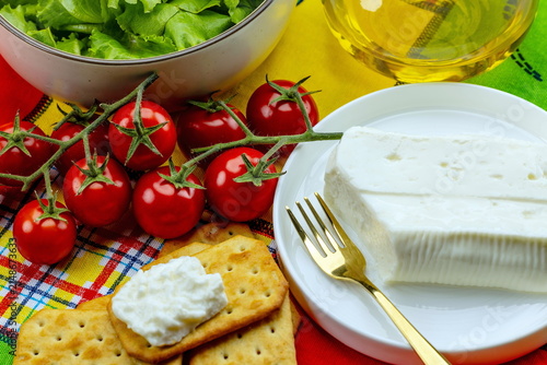 Fotografie Primo piano di formaggio italiano a pasta molle con insalata , pomodori e cracke