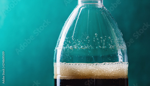 Close up Dark Beer Bottle with Frothy Foam.
