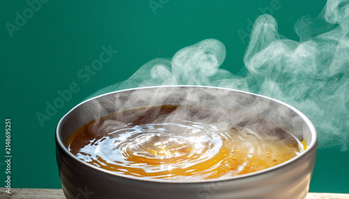 Steaming simmering pot of orange curry bubbling.