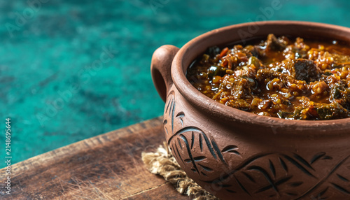 Rustic clay pot stew by poolside comforting aroma.