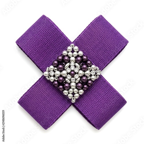 A purple sparkly cross shaped brooch with rhinestones and beads