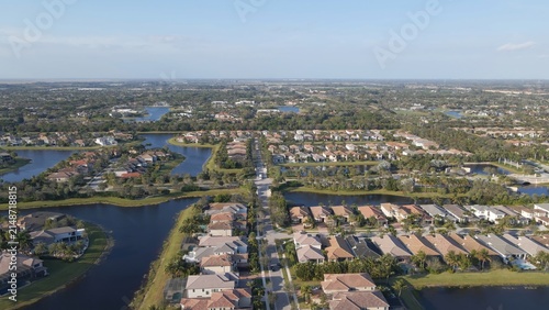 Aerial view of a residential neighborhood with houses, streets, and interconnected lakes in Boca Raton, Florida, United States.
