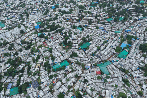 Aerial view of the dense Rohingya Camp featuring countless makeshift shelters with white tarpaulin roofs and green accents in Ukhia, Chittagong Division, Bangladesh.