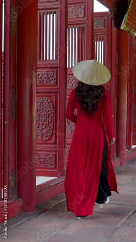 Vertical video Slow motion, Vietnamese woman in red dress wearing conical hat in Hue Royal Palace, Vietnam