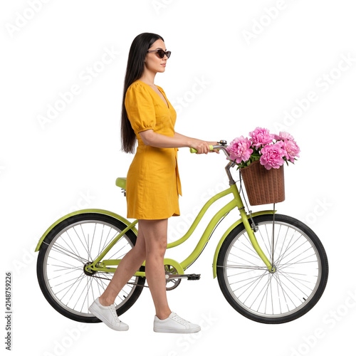 Woman in yellow dress walking a bicycle with flower basket, isolated