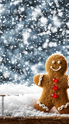 Gingerbread Man Cookie Standing in Snow With Falling Snowflakes in Background