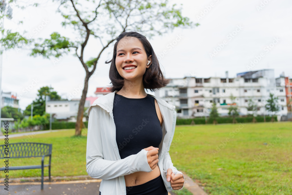 Fototapeta premium Asian sporty woman running in public park