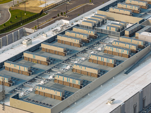 Aerial view of data center building roof featuring rows of industrial cooling units and HVAC systems