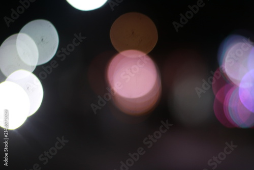 Photography Abstract night scene with soft, out-of-focus circular light orbs in white, pink,