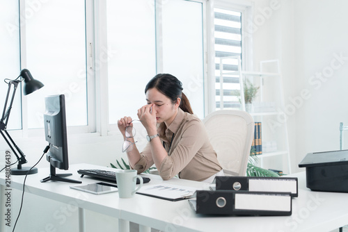Young Businesswoman Working at Office Desk While Managing Documents and Mobile Communication.