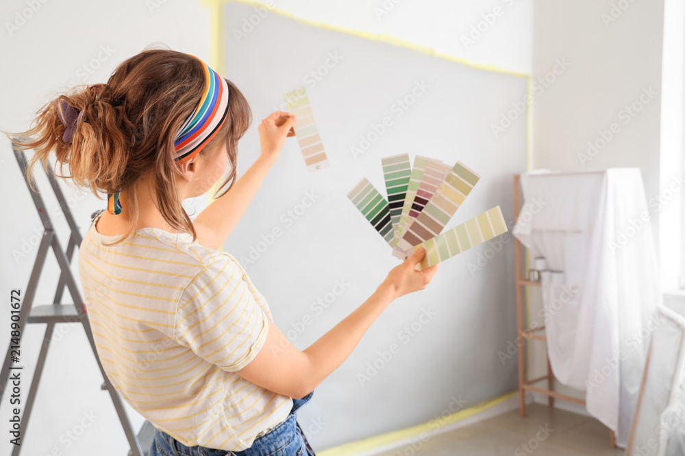 Obraz premium Young woman with paint color palettes during repair in room
