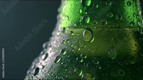 Macro shot of cold green glass beer bottle covered with refreshing water drops