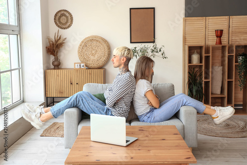 Offended young couple sitting at home