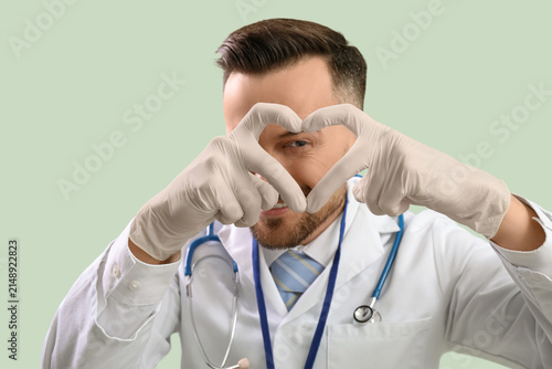Male doctor making heart wi...