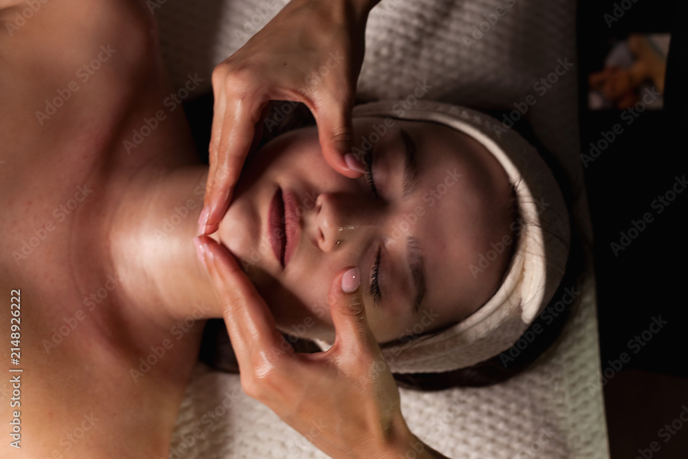 Fototapeta premium Relaxing Facial Massage for Rejuvenation in a Calm Indoor Setting