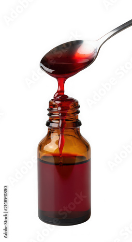 Spoon pouring red syrup into glass bottle isolated on transparent