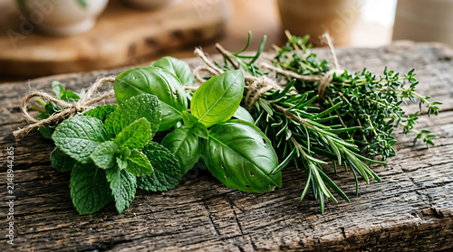 Fresh culinary herbs tied with twine on rustic wooden background rosemary culinary seasoning aromatic ingredient