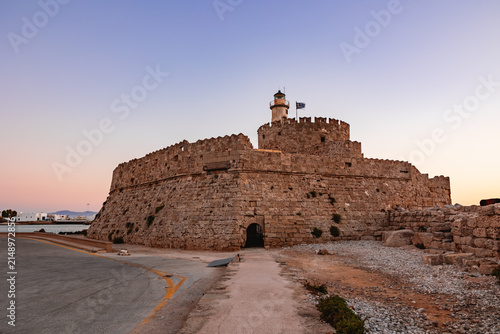 Obraz na płótnie Fort of Saint Nicholas with its central lighthouse and waving Greek flag at the tip of Mandraki Harbour in Rhodes, Greece