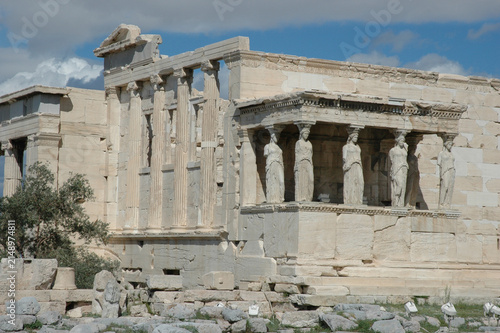 Bild auf Leinwand The historic Caryatid porch and marble columns of the ancient Erechtheion temple stand under a cloudy blue sky at the Acropolis in Athens Greece