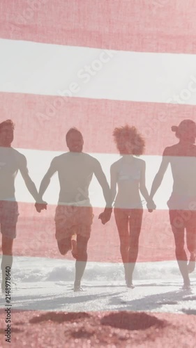 American flag waving against group of friends holding hands running together on the beach