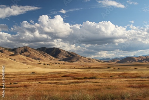 Vast California Landscape with Rolling Hills and Cloudy Sky.