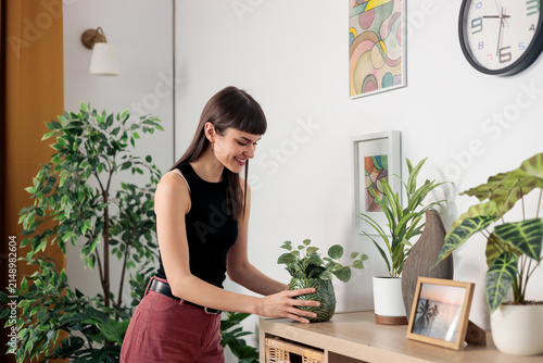 Obraz na płótnie Woman arranging houseplant, caring for home decor