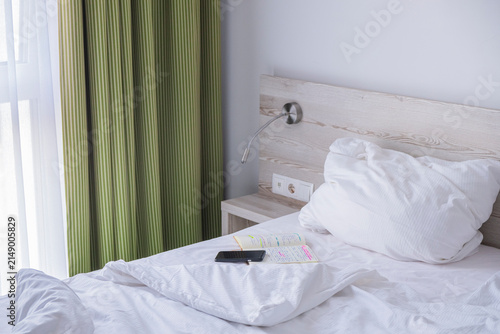 A smart phone on a neatly made hotel bed, symbolizing a peaceful morning routine.