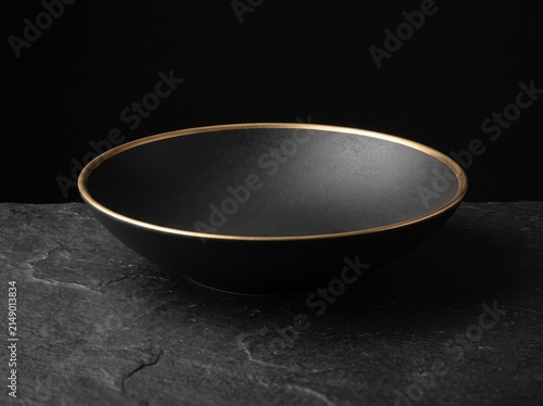 Black Ceramic Bowl with Gold Rim on Dark Stone