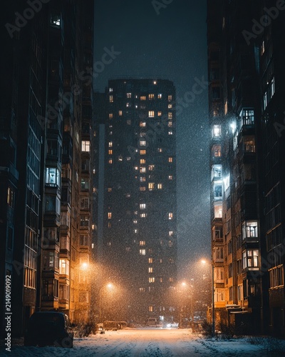 Urban Nightscape - Illuminated Buildings and Snowy Street in Foggy City.