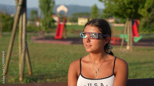 Bild auf Leinwand Young Caucasian woman watching total solar eclipse safely in natural park settin