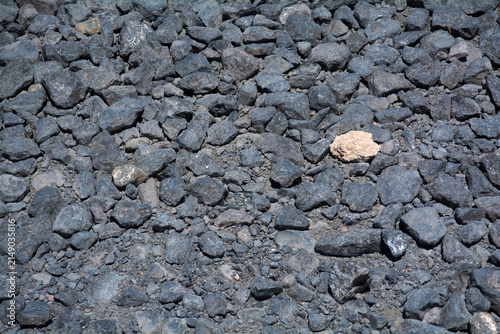 фотографія Dark volcanic basalt gravel and stones covering volcanic ground at Cuatro Puertas archeological area