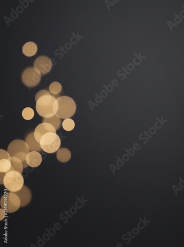 Golden Bokeh Light Particles Floating on Dark Background
