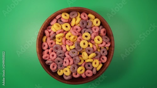 Stopmotion: eating colorful corn balls from a wooden bowl	