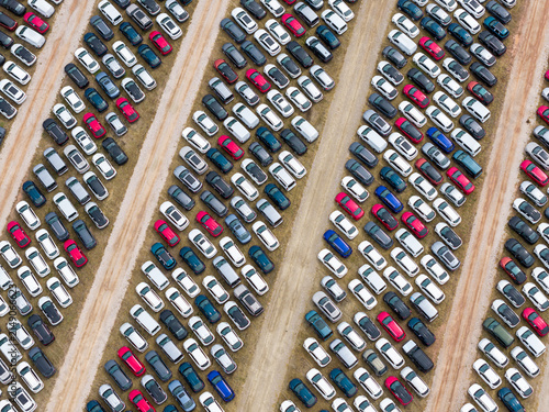Aerial view of rows of parked cars in a car forwarding lot with various colors and models arranged in neat lines in Poland.