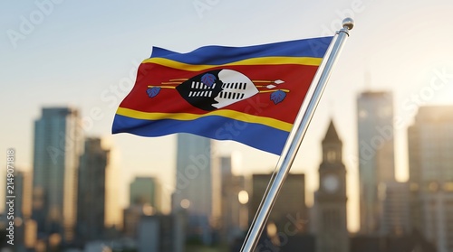 National flag of Eswatini waving on metal pole with blurred urban cityscape background during sunset