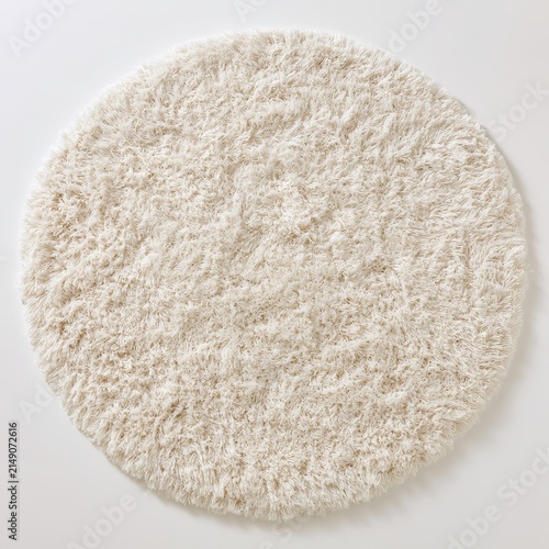 Fluffy round cream shag rug sits on white background.